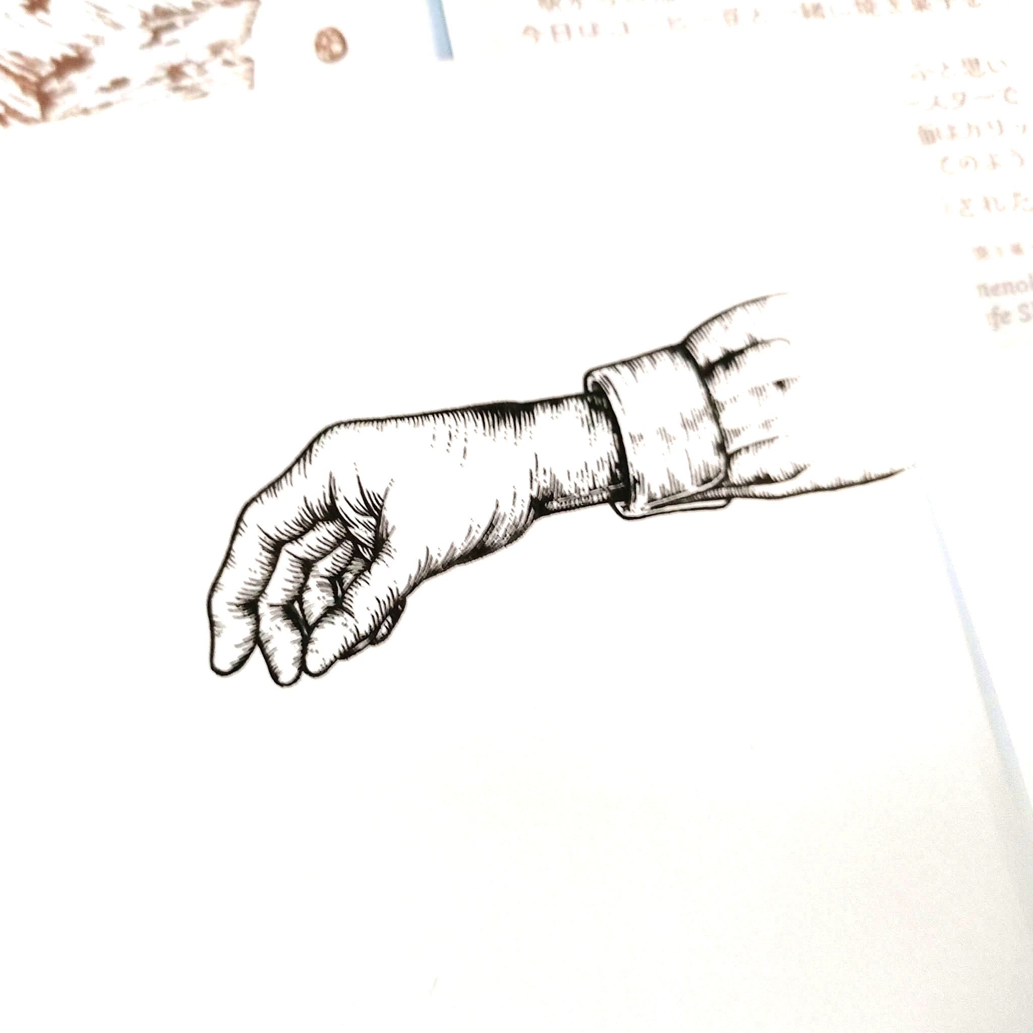 焼き菓子をつかもうとしている手を描いたペン画原画を撮影したものです。